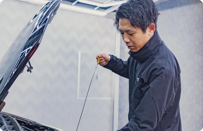 男性が車のオイルを確認している画像