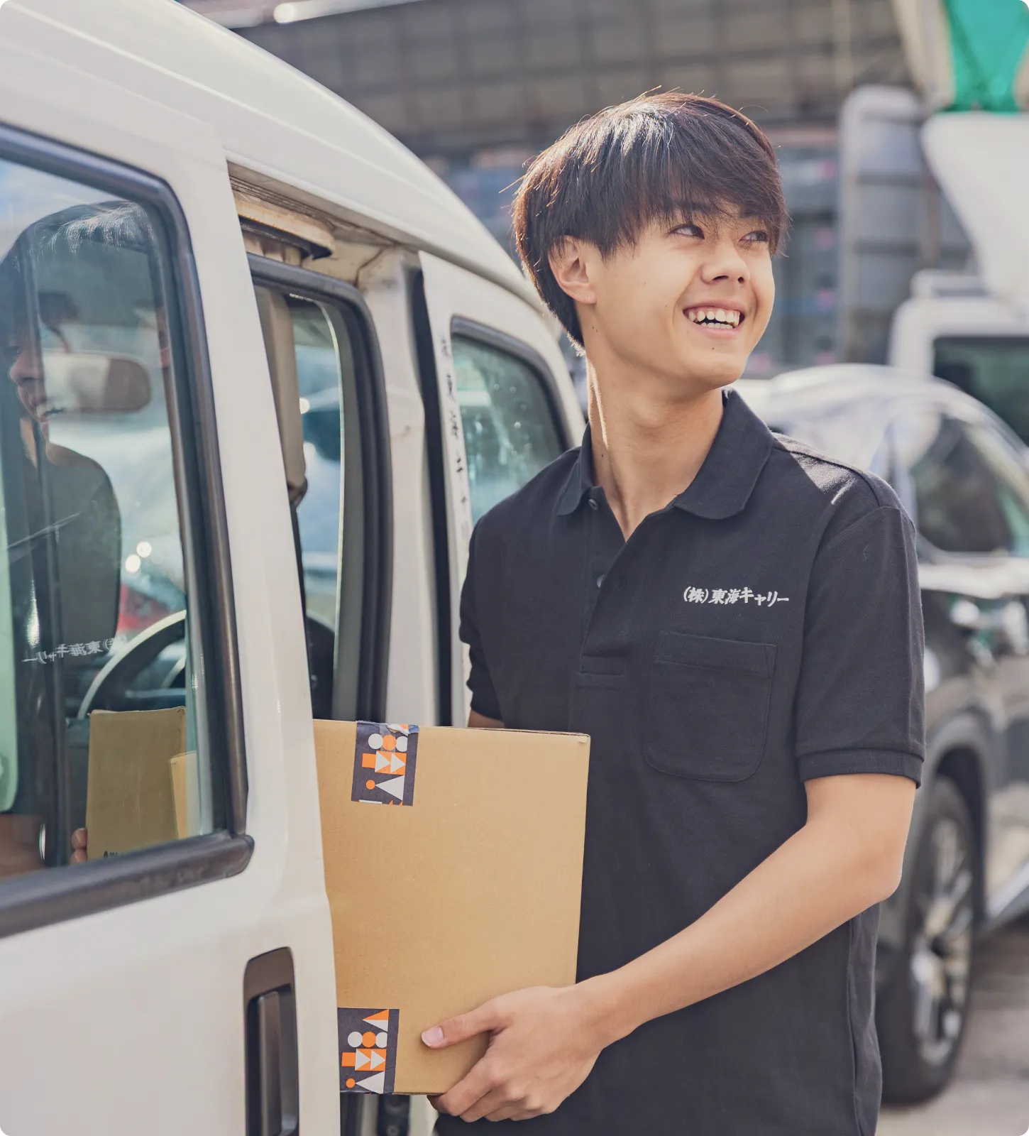 笑顔の男性がダンボールを持っている画像