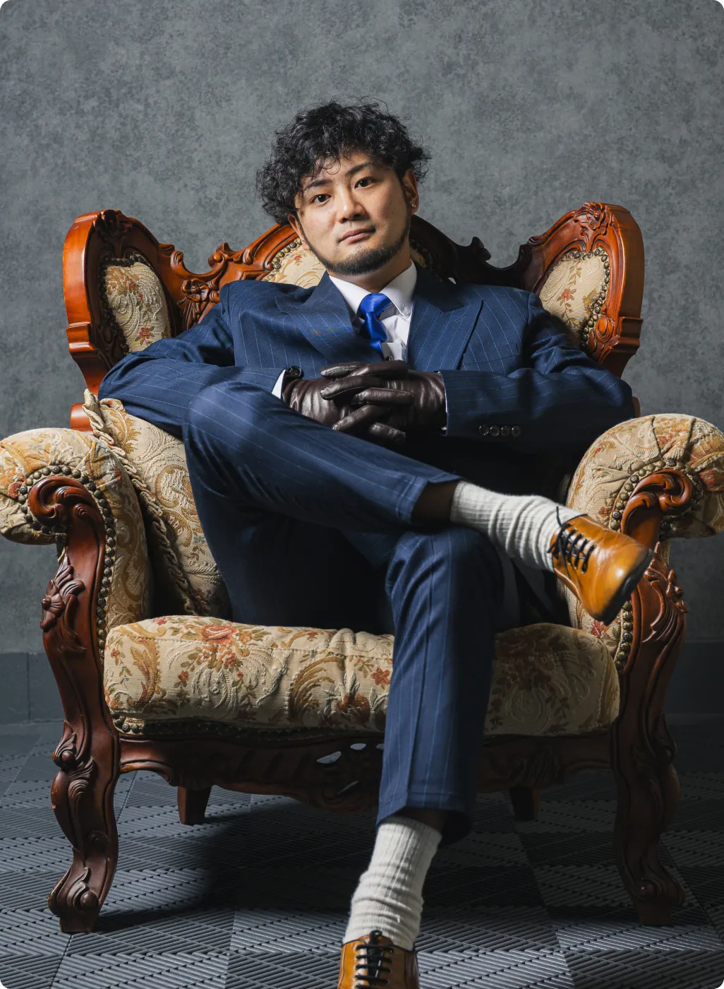 スーツを着た代表が椅子に座って足を組んでいる写真